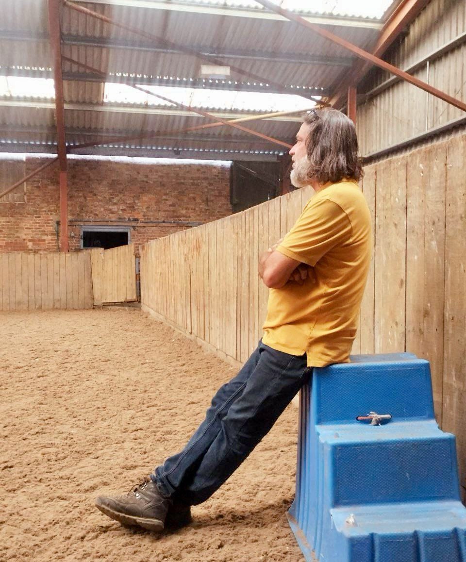 Isaac Ares standing in quiet observation inside the arena, reflecting during a training session.