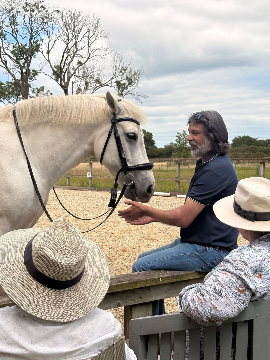 Isaac Ares teaching horsemanship beside a horse during a practical training session.